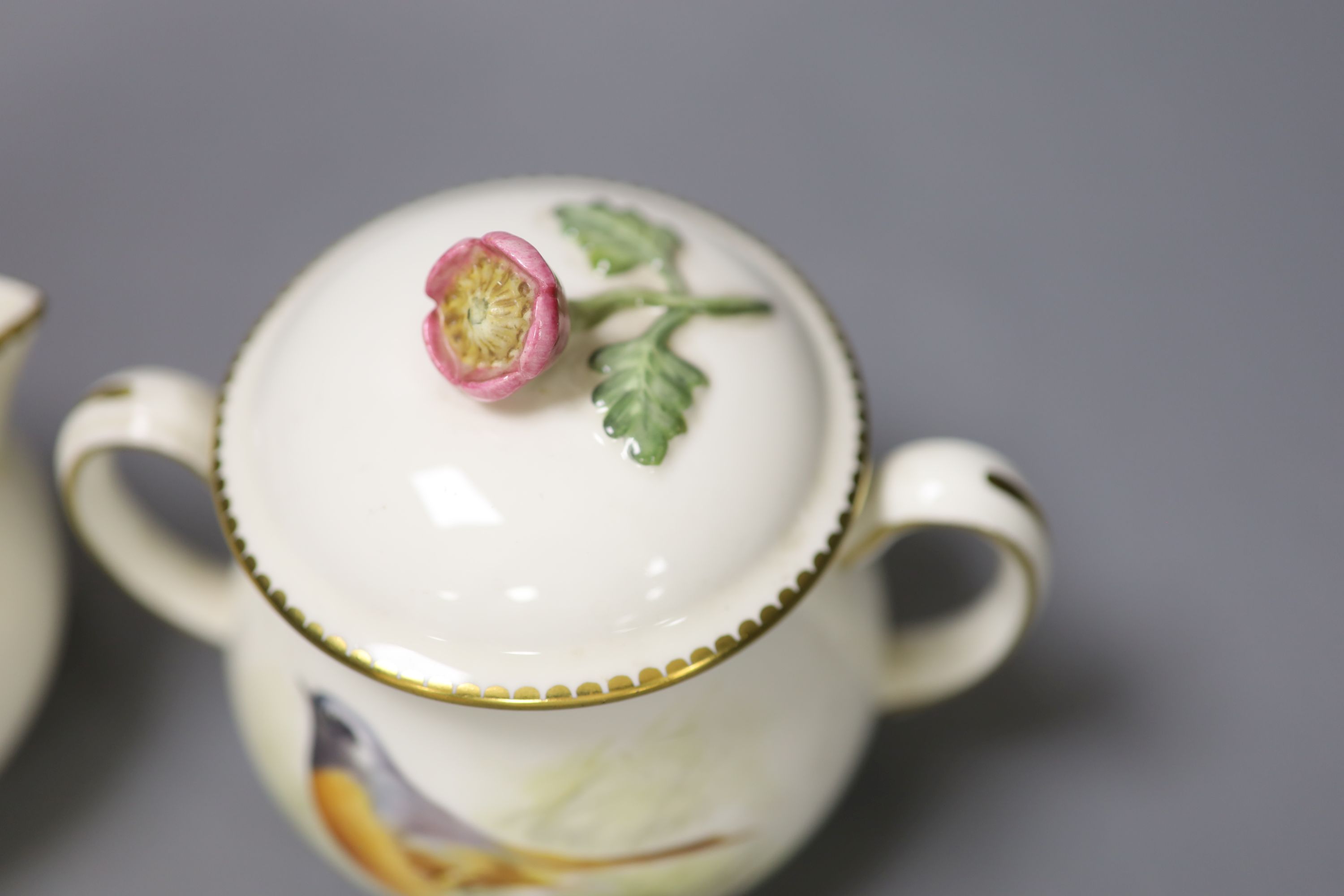 A Royal Worcester sugar bowl painted with a Redstart and cover and a cream jug painted with a Wren by E. Townsend, signed black mark